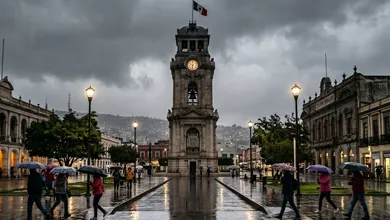 Reloj Monumental de Pachuca bajo un cielo completamente nublado y calles mojadas por la lluvia.