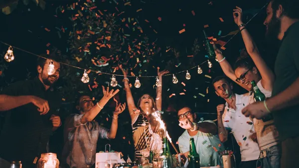 Personas celebran Año Nuevo escuchando música y brindando.
