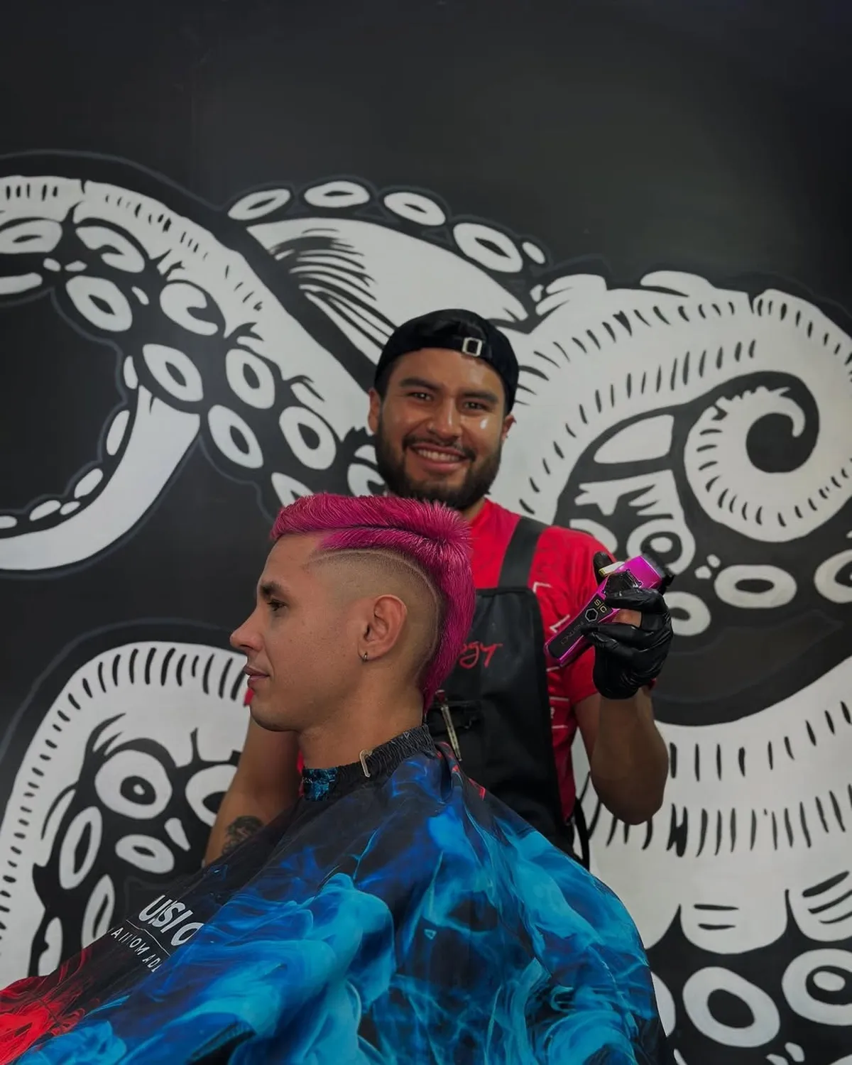 Barbero hace corte de cabello a cliente