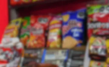Botanas de maíz y papas exhibidas en un anaquel de supermercado.