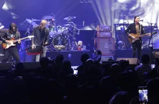 Caifanes durante una presentación en vivo con escenario iluminado.