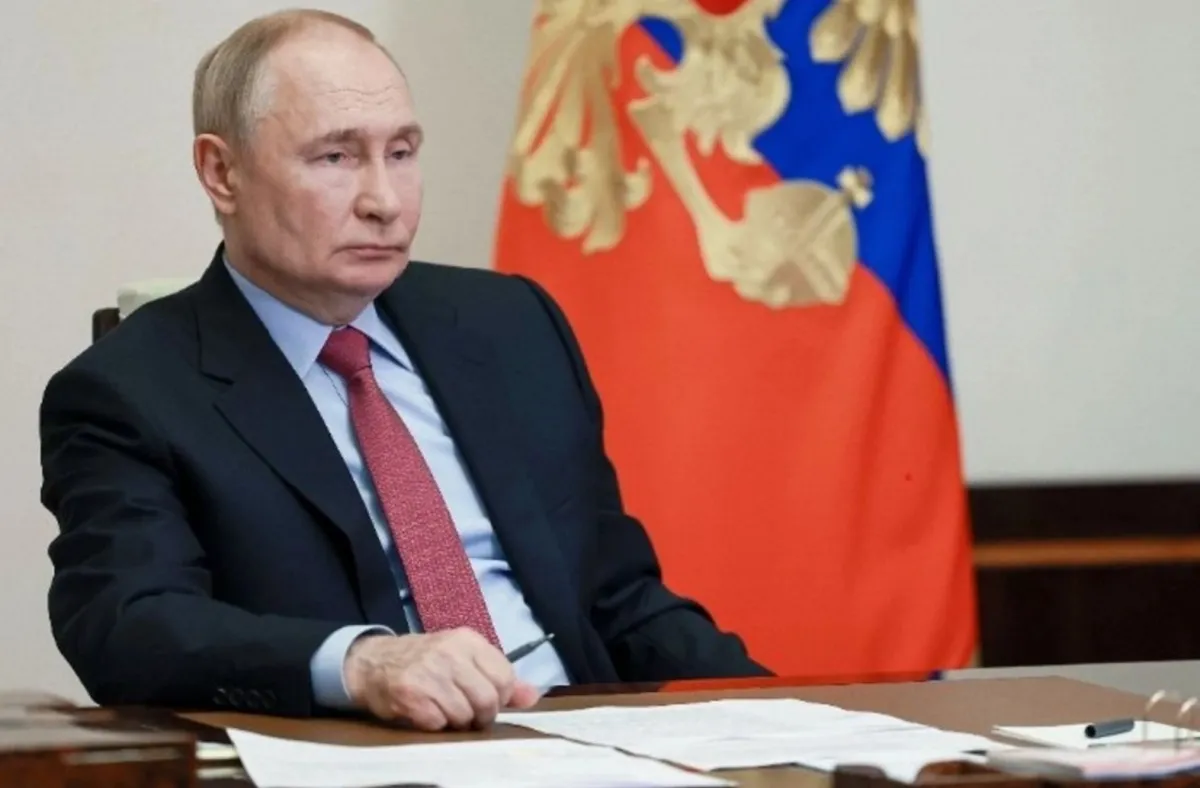 Vladimir Putin sentado frente a documentos oficiales, con la bandera de Rusia al fondo, durante una conferencia posterior a la cumbre con Trump