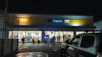 Policías resguardan la zona tras asalto en Coppel de Tezontepec.