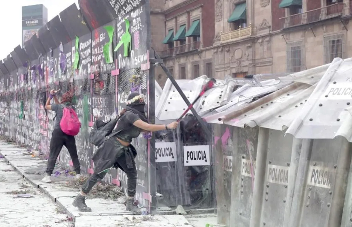 Un grupo de jóvenes intenta atravesar las vallas y el cerco policiaco que resguardan el Palacio Nacional, en el marco del Día Internacional de la Mujer, el 8 de marzo de 2021. Foto Roberto García Ortiz