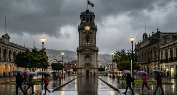 Reloj Monumental de Pachuca bajo un cielo completamente nublado y calles mojadas por la lluvia.