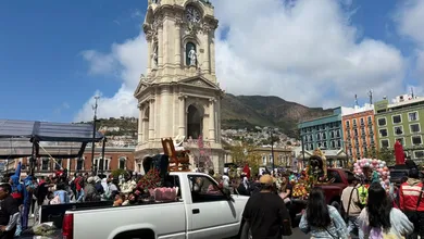 Procesión del Día de la Santa Muerte en Pachuca con veladoras y figuras coloridas.