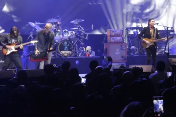 Caifanes durante una presentación en vivo con escenario iluminado.