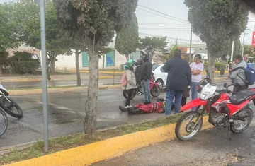 Paramédicos atienden a motociclista lesionado tras derrape en avenida Juárez de Tizayuca.