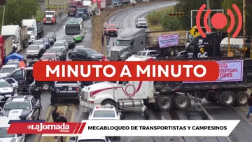 Bloqueo carretero con filas de vehículos detenidos.