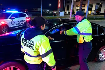 Personal de seguridad realiza una prueba de alcoholímetro a un conductor.
