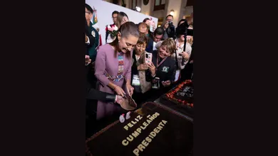 La presidenta Claudia Sheinbaum parte un pastel durante la celebración de su cumpleaños número 64 en Palacio Nacional.